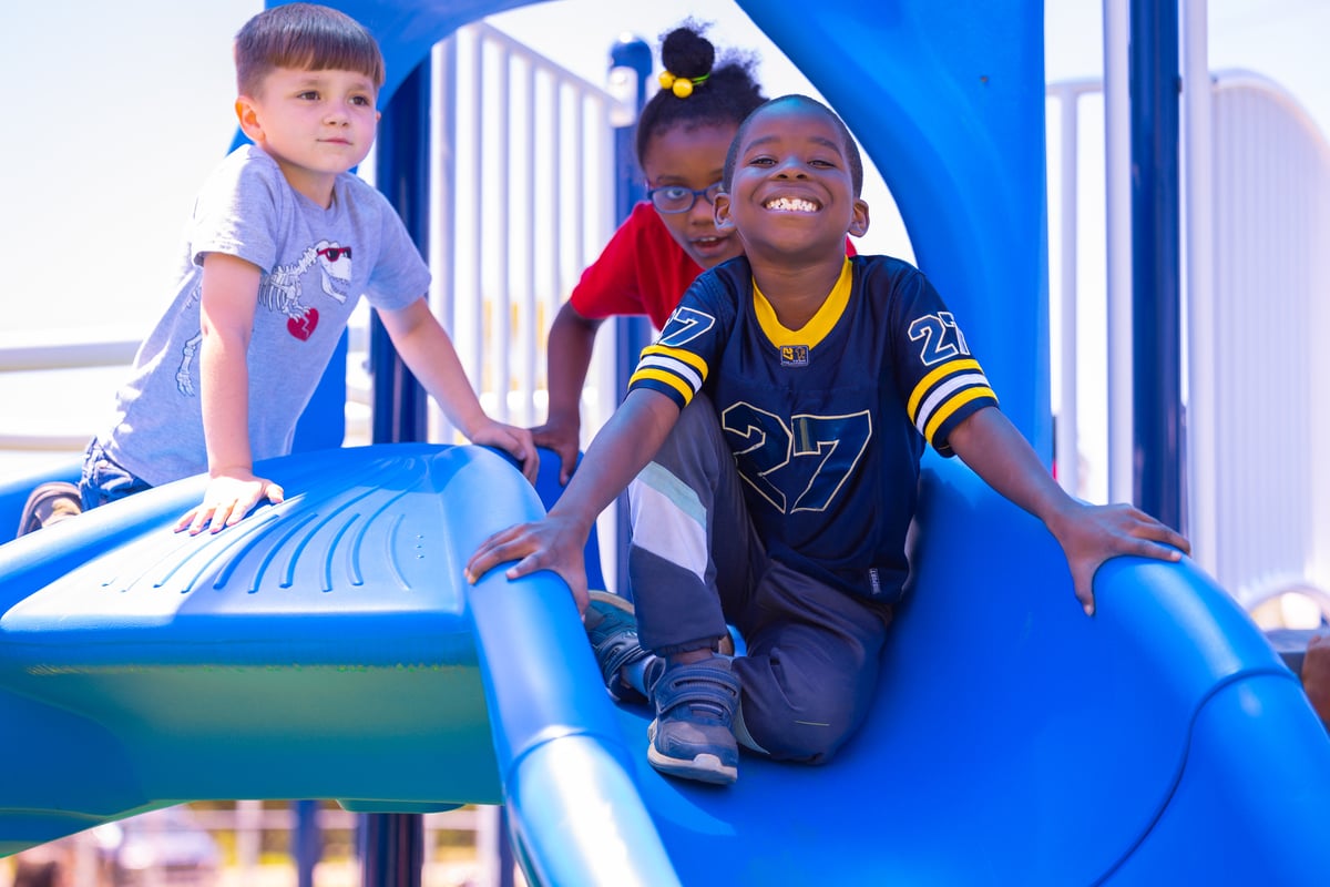 Kids smiling on the slide